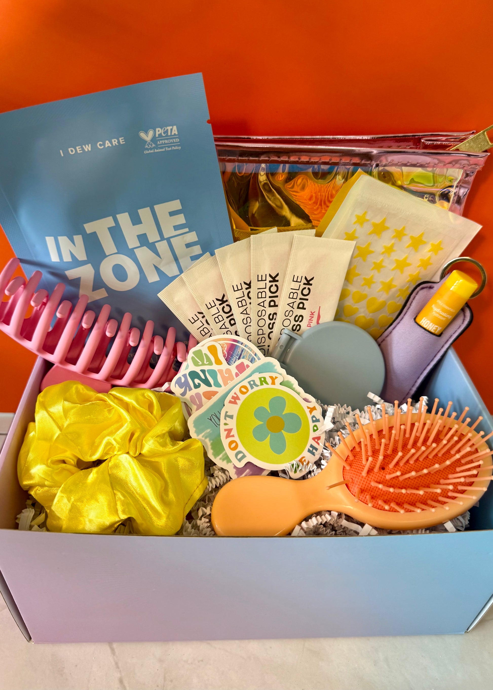 Multi colored rainbow theme gift set with beauty and self-care essentials makeup- bag, lip balm and face mask